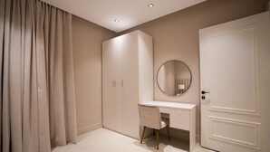 Een slaapkamer met een bed, een bureau en een kledingkast.