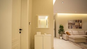Een moderne woonkamer met een bank, een kast en een spiegel.