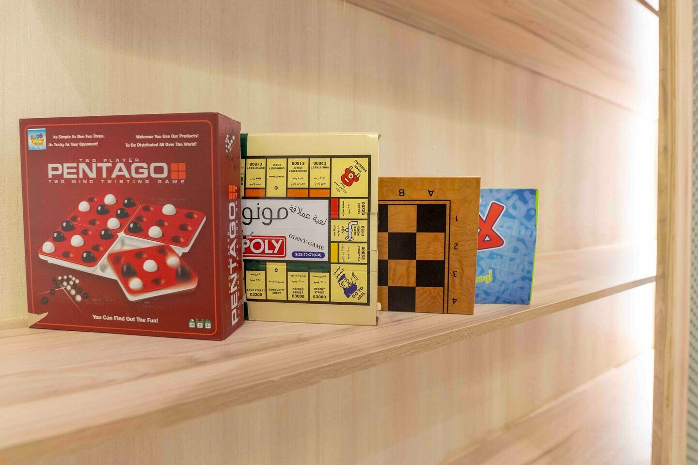 Una estantería con tres juegos de mesa: Pentago, Giggo y otro juego con tablero de ajedrez.