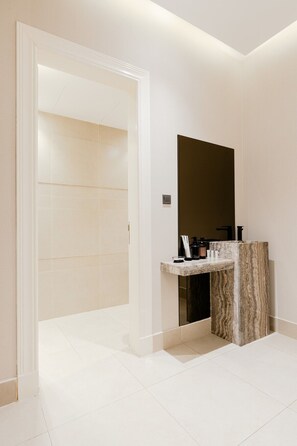 A modern bathroom with a marble sink, a large mirror, and a white tiled floor. - Three BR Spacious & Luxurious Flat in Hittin (Riyadh)