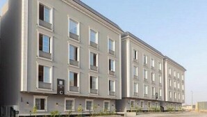 A multi-story building with a symmetrical facade, evenly spaced windows, and a flat roof. - Three BR Spacious & Luxurious Flat in Hittin (Riyadh)