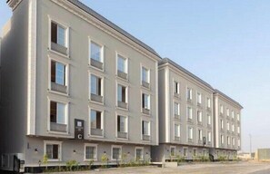 A multi-story building with a symmetrical facade, evenly spaced windows, and a flat roof. - Three BR Spacious & Luxurious Flat in Hittin (Riyadh)