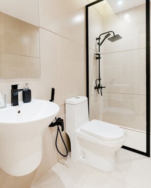 A modern bathroom with a white sink, toilet, and glass-enclosed shower area. - Three BR Spacious & Luxurious Flat in Hittin (Riyadh)
