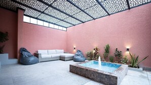 Espaço moderno em ambiente interno com piscina, área de estar e plantas decorativas.