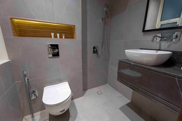 Une salle de bain moderne équipée de toilettes, d’une douche et d’un lavabo.