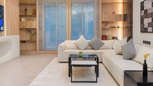 A modern living room with a sofa, coffee table, and a large window with a view. - Luxurious 2-br Flat With Relaxation Space lll (Riyadh)