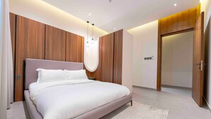 Un dormitorio moderno con una cama grande, paneles de madera y un armario empotrado.