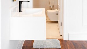 Een moderne badkamer met een wit wastafel, toilet en douche.
