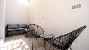 A small, sunlit outdoor seating area with a sofa and two chairs. - Trendy Apartment in Almohamadia (Riyadh)