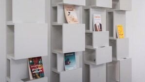 A modern, white shelving unit with books and small items displayed on it. - Trendy Apartment in Almohamadia (Riyadh)