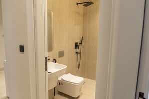 A modern bathroom with a toilet, sink, and shower. - Modern Studio & Shared Garden in Prime Location (Madinah)