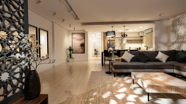 A modern living room with a sofa, coffee table, and decorative plants. - Stylish and Cozy Flat in Almughrizat (Riyadh)
