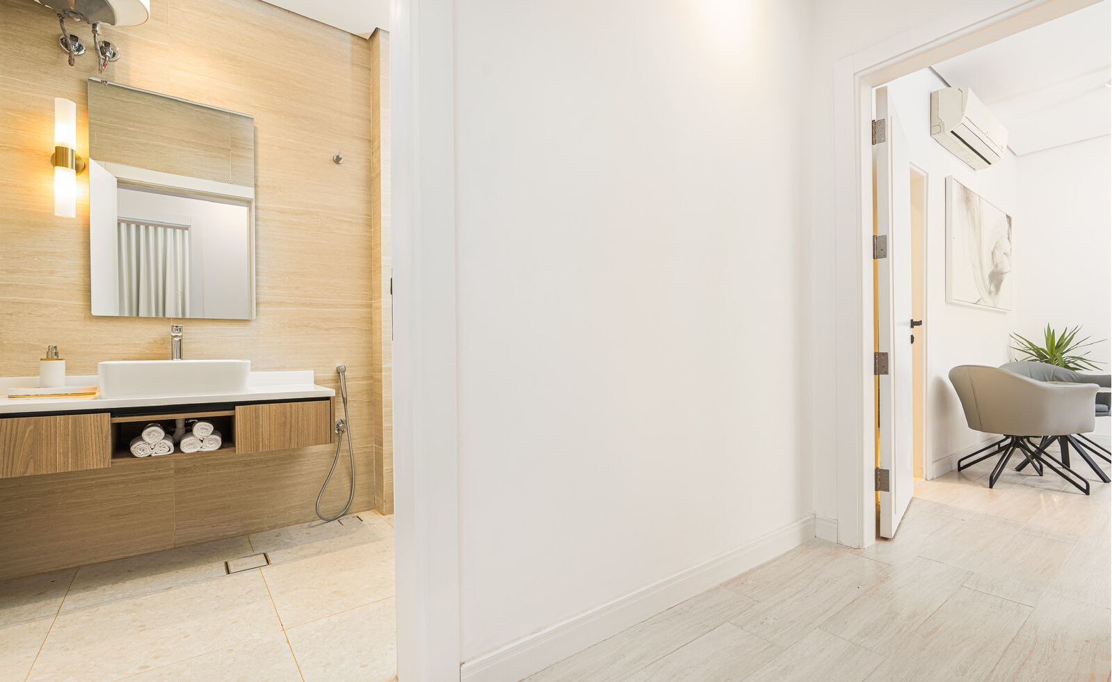A modern bathroom with a wooden vanity, a large mirror, and a shower.