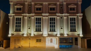 A large, multi-story building with a symmetrical facade, featuring large windows and columns. - Modern Almughrizat Apt, Workspace, Free Parking (Riyadh)