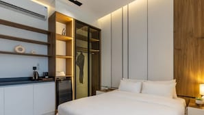 Een moderne slaapkamer met een groot bed, inbouwkast en nachtkastjes.