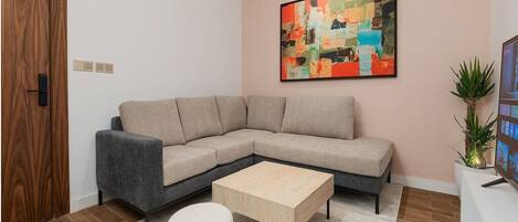 A modern living room with a sectional sofa, a coffee table, and two ottomans.