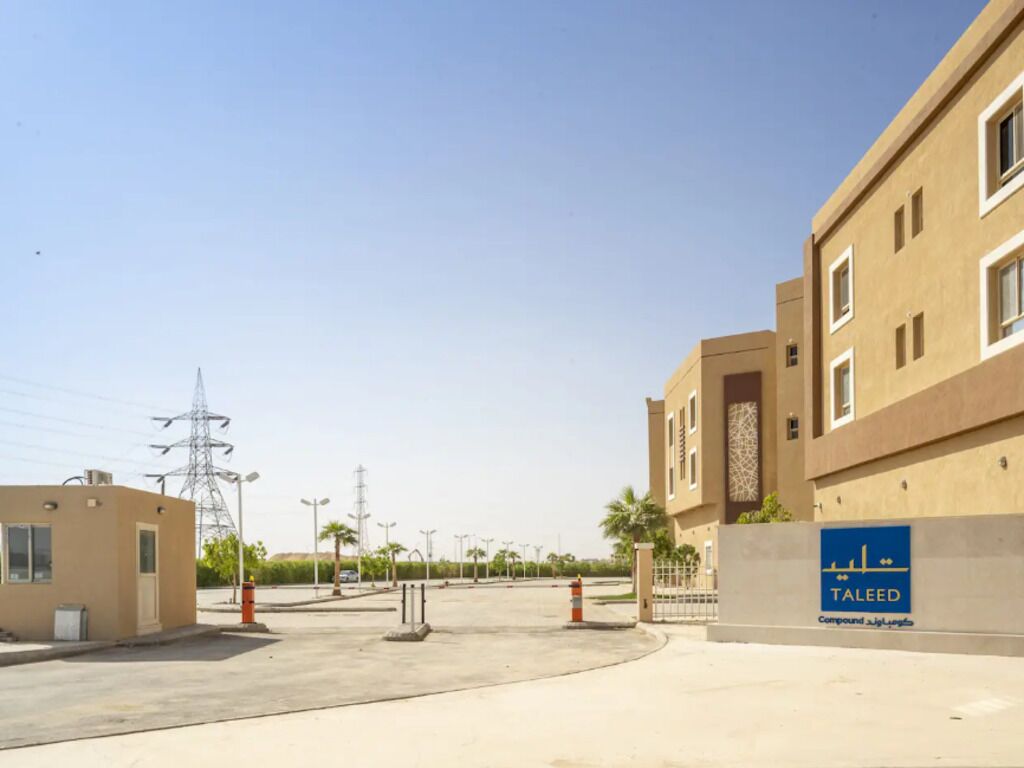 A modern building with a sign reading "Taleed Compound."