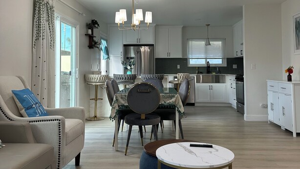 Un salon moderne comprenant un canapé, une table basse et un coin repas avec une table et des chaises.