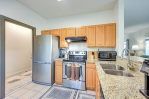 A kitchen with wooden cabinets, stainless steel appliances, a granite countertop, and a double sink. - 7 Mi to Dtwn Jacksonville: Riverfront Home w/ Deck (Jacksonville)