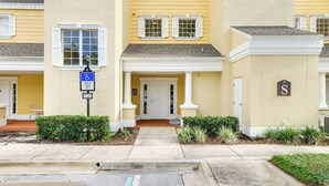 A yellow building with white shutters and a wheelchair-accessible sign. - Golf Views: Kissimmee Condo on Reunion Course (Kissimmee)