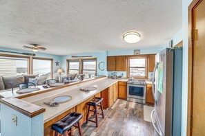 A spacious kitchen with a long island, wooden cabinets, a built-in oven, and a refrigerator. - Walk to Beach: Dog-friendly Home in Lincoln City (Lincoln City)