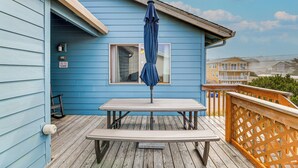 A blue building with a wooden deck, a picnic table, and a blue umbrella. - Walk to Beach: Dog-friendly Home in Lincoln City (Lincoln City)