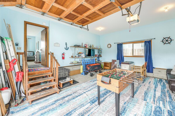 A room with a foosball table, wooden shelves, a window with curtains, and a ceiling fan. - Walk to Beach: Dog-friendly Home in Lincoln City (Lincoln City)
