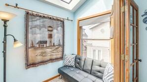 A room with a skylight, a framed picture on the wall, a sofa with cushions, and a wooden door. - Walk to Beach: Dog-friendly Home in Lincoln City (Lincoln City)