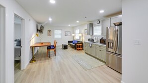 A modern kitchen with a dining area, a refrigerator, and a microwave.