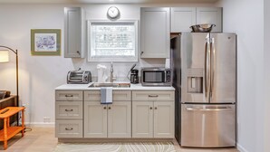 A modern kitchen with a stainless steel refrigerator, a microwave, a toaster, and a sink.
