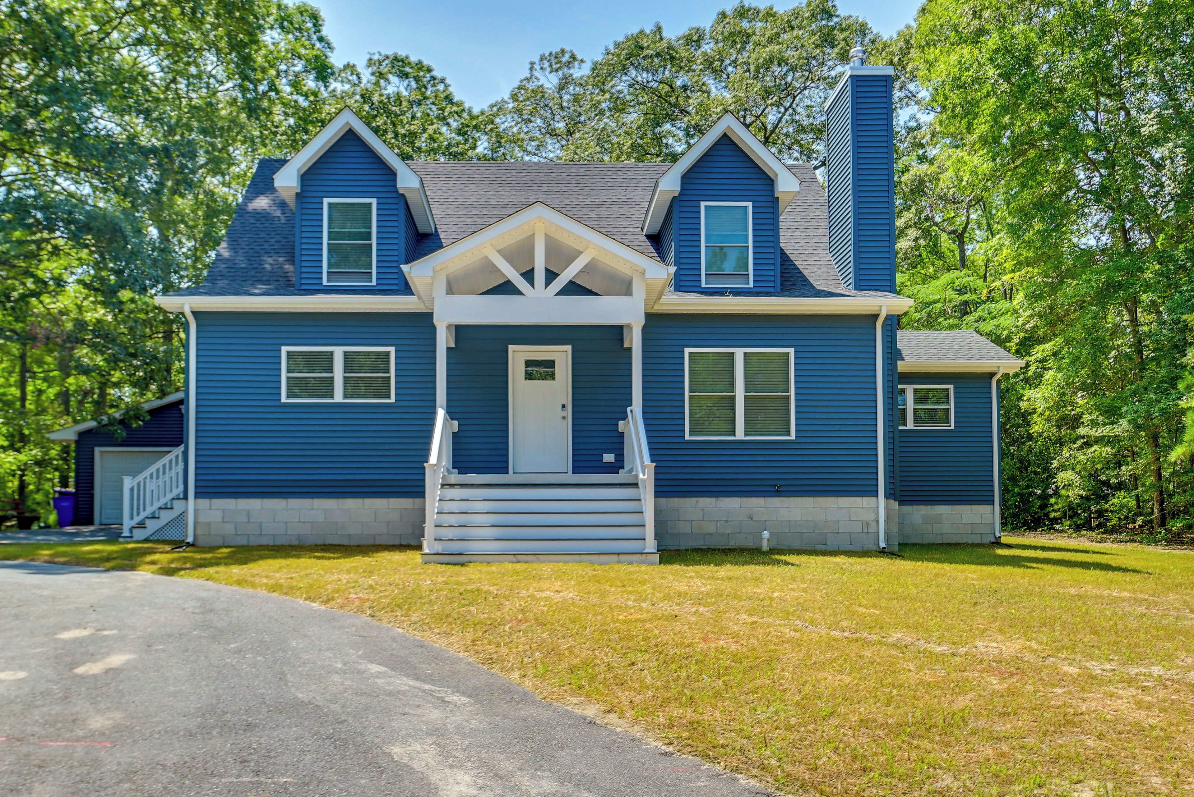 A two-story house with a front porch, a chimney, and a garage.