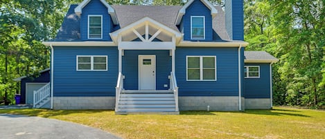 A two-story house with a front porch, a chimney, and a garage.