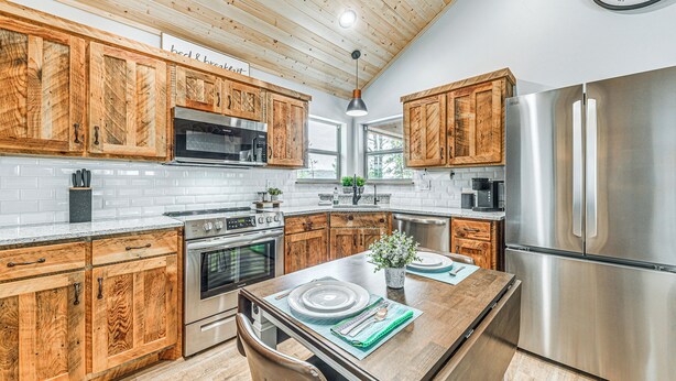 Una cocina moderna con armarios de madera, electrodomésticos de acero inoxidable y una isla central.