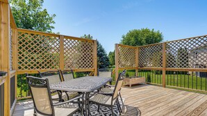 Une terrasse en bois avec une table et des chaises, entourée d’une clôture en bois.