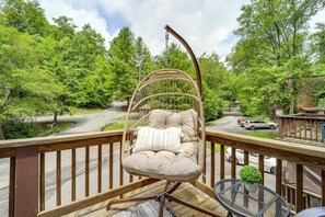 A wicker chair with a cushion and pillow on a wooden deck overlooking a street with cars and trees. - 1 Mi to Sugar Mtn: Updated Banner Elk Escape! (Banner Elk)