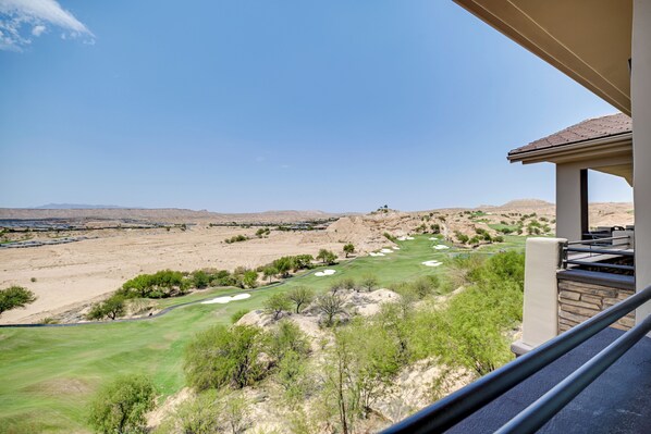 A view from a balcony overlooking a golf course with bunkers and a clear sky. - Golf Course Views & Private Deck: Mesquite Condo! (Mesquite)