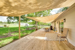 A covered outdoor patio with wooden flooring, a patterned rug, and outdoor furniture. - Blue Ridge Retreat on 10-acre Farm: Rural Reset! (Blue Ridge)
