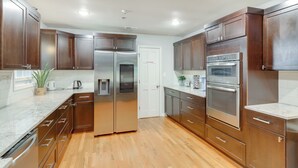 A modern kitchen with wooden cabinets, stainless steel appliances, and a marble countertop. - Ideal for Reunions & Retreats: Brooks Getaway! (Brooks)