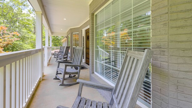 A covered porch with wooden rocking chairs and a brick wall. - Ideal for Reunions & Retreats: Brooks Getaway! (Brooks)