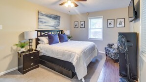 A bedroom with a bed, bedside table, nightstand, ceiling fan, and a standing fan. - 6 Mi to Percy E Quin State Park: Mccomb Home! (McComb)