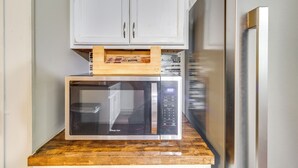 A kitchen with a microwave on a wooden countertop, a white cabinet above, and a stainless steel refrigerator to the right. - 6 Mi to Percy E Quin State Park: Mccomb Home! (McComb)