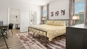 A bedroom with a bed, bedside tables, a desk, and a chair. - Modern 3BR Home in San Antonio (San Antonio)