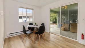 Un coin repas avec une table ronde, quatre chaises et une petite plante.