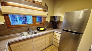 A modern kitchen with a stainless steel refrigerator, a microwave, and a sink.