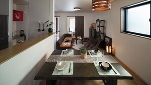 A modern dining area with a wooden table set for two, a sofa in the background, and a large window on the right. - 福助Tofu   OsakaTsuruhashi 5mins JRloop Direct Nipponbashi;Namba;Nara;USJ;Tennoji  (Ikuno-ku Tsuruhashi)