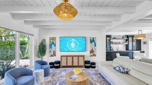 A modern living room with a large window, a dining area, and a kitchen. - Steps to Beach / Heated Pool / Kiwi Key / Residences (Fort Lauderdale)