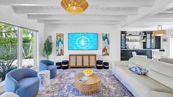 Una sala de estar moderna con un ventanal grande, un comedor y una cocina.