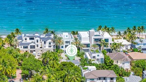 A coastal residential area with modern houses, palm trees, and a view of the ocean. - Steps to Beach / Heated Pool / Kiwi Key / Residences (Fort Lauderdale)