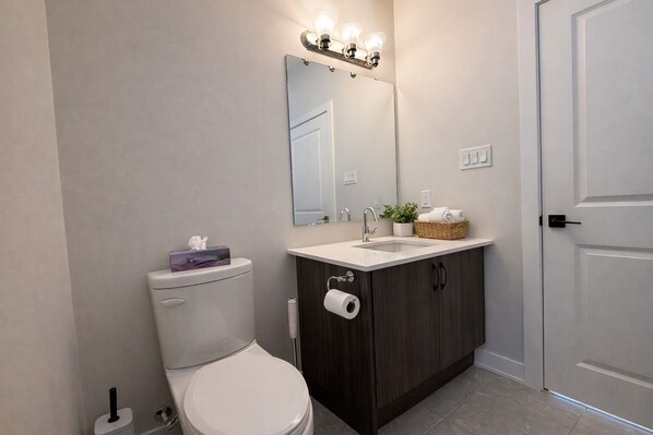 Un baño con inodoro, lavabo y espejo.