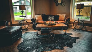 Una sala de estar acogedora con un sofá de cuero, una mesa de centro y una alfombra grande.